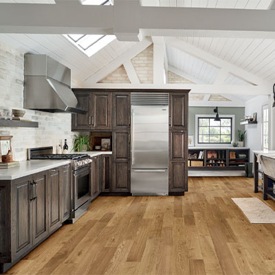 hardwood flooring in kitchen with dark wood cabinetry and metal accents.